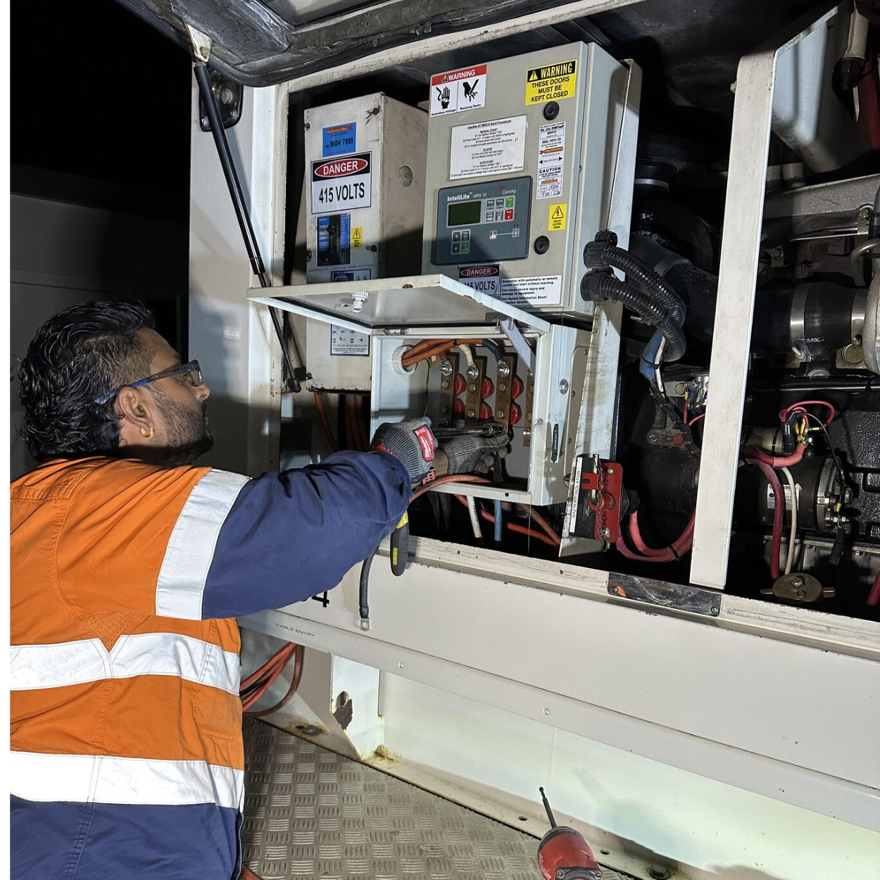 Ajen Singh from Mega Power Services working on 415V generator control equipment during an emergency call-out in Sydney